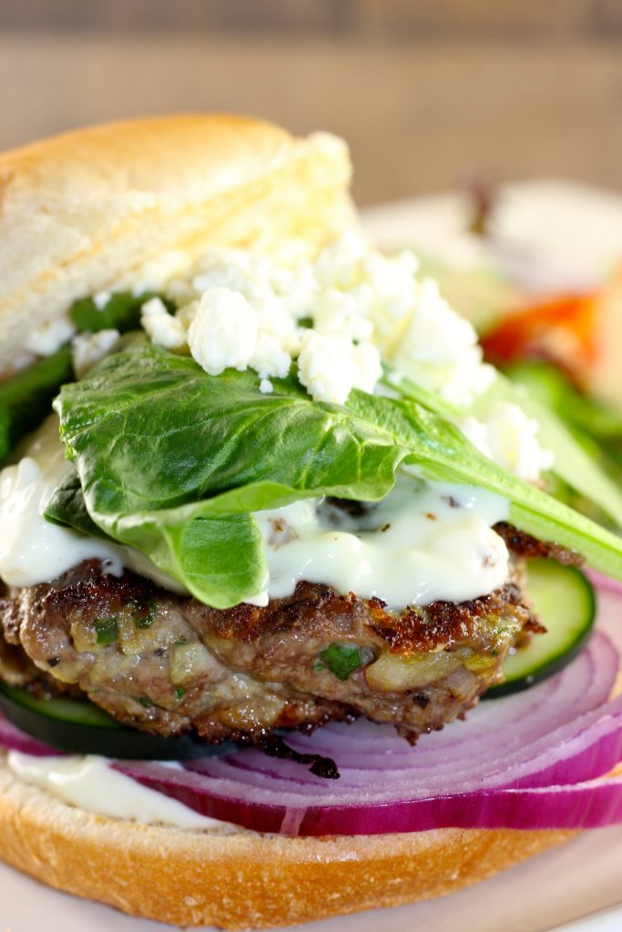 Greek lamb burger with onion cucumber spinach and feta