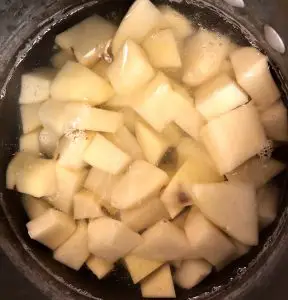 Cut up potatoes in a pot of water