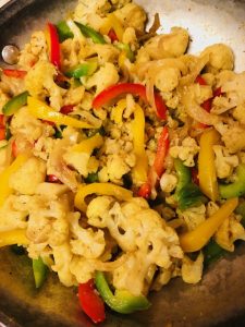 cauliflower, onion, and bell peppers in a pan