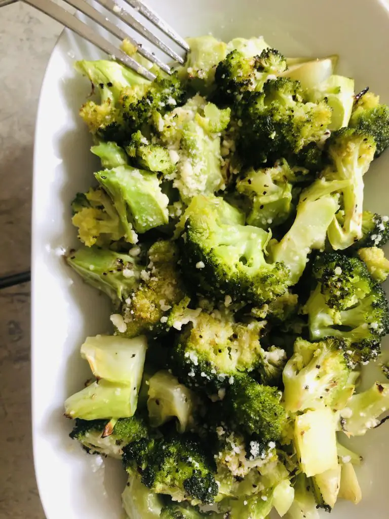 Roasted Broccoli With Parmesan on a plate with a fork