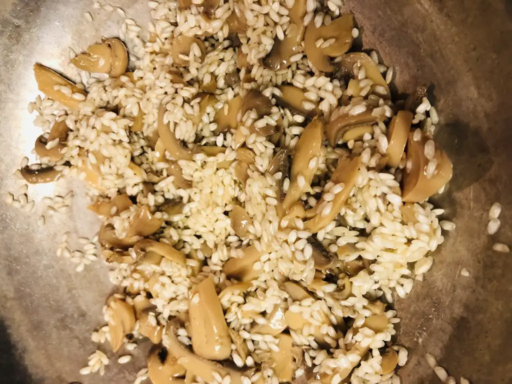 Mushrooms and arborio rice in a skillet