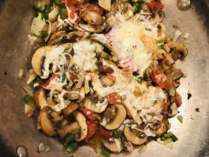 sliced mushrooms, diced tomato, diced jalapeno, diced onion, and shredded cheese in a skillet