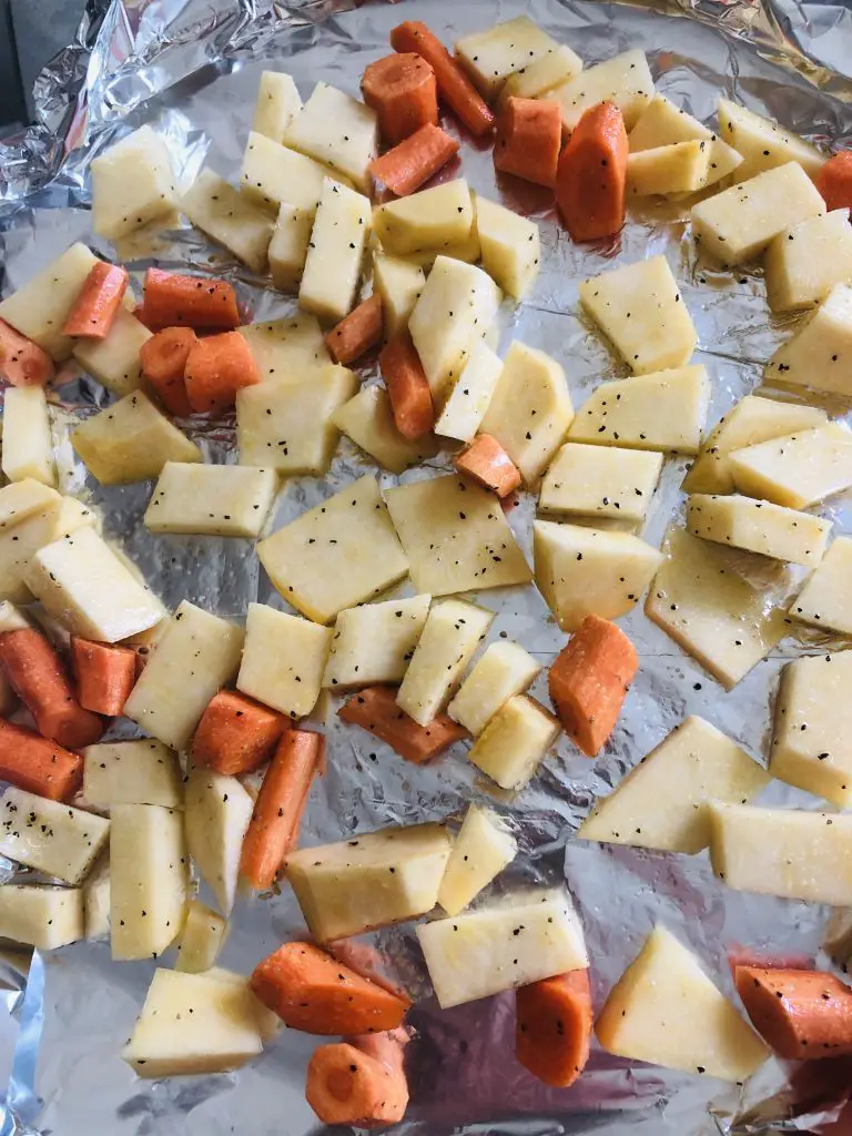 chopped up rutabaga and carrots on a roasting tray