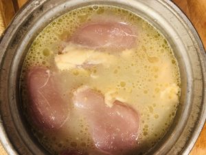 rice, chicken, and Hainanese Chicken Rice spice paste in a rice cooker