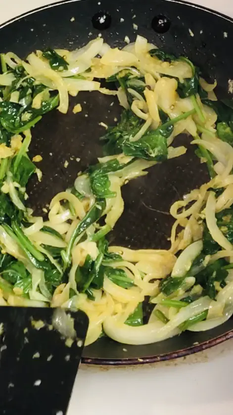Spinach mixture with 2 wells in a nonstick pan