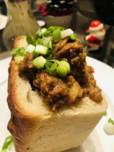 Bunny Chow on a white plate with a santa claus pepper shaker