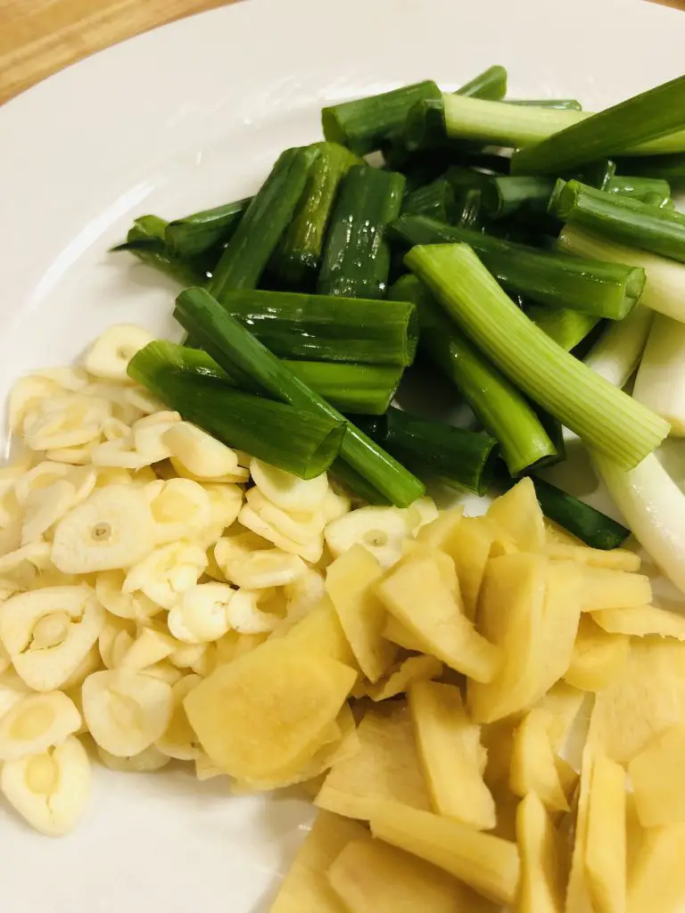 sliced ginger, sliced garlic, and chopped scallions