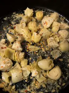 Cut up artichokes, minced garlic in melted butter on a cast iron pan seasoned with fresh ground black pepper and chili flakes