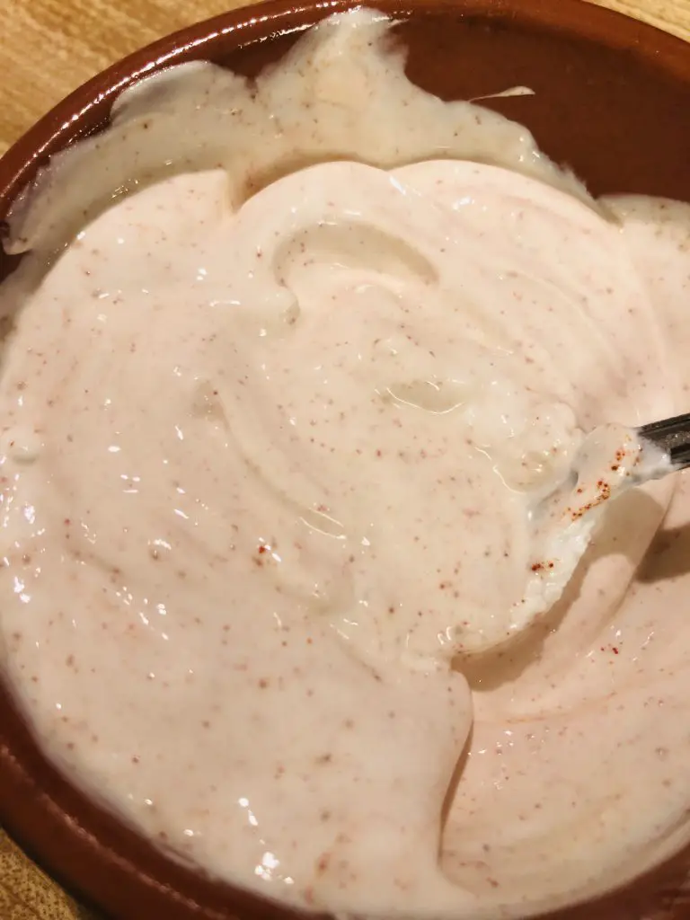 Pink hued sour cream in a bowl