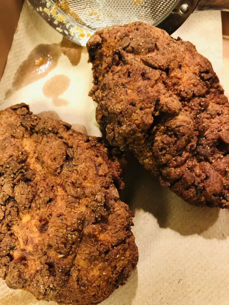 Fried chicken draining on paper towels