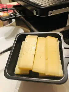 Sliced raclette cheese in a small tray