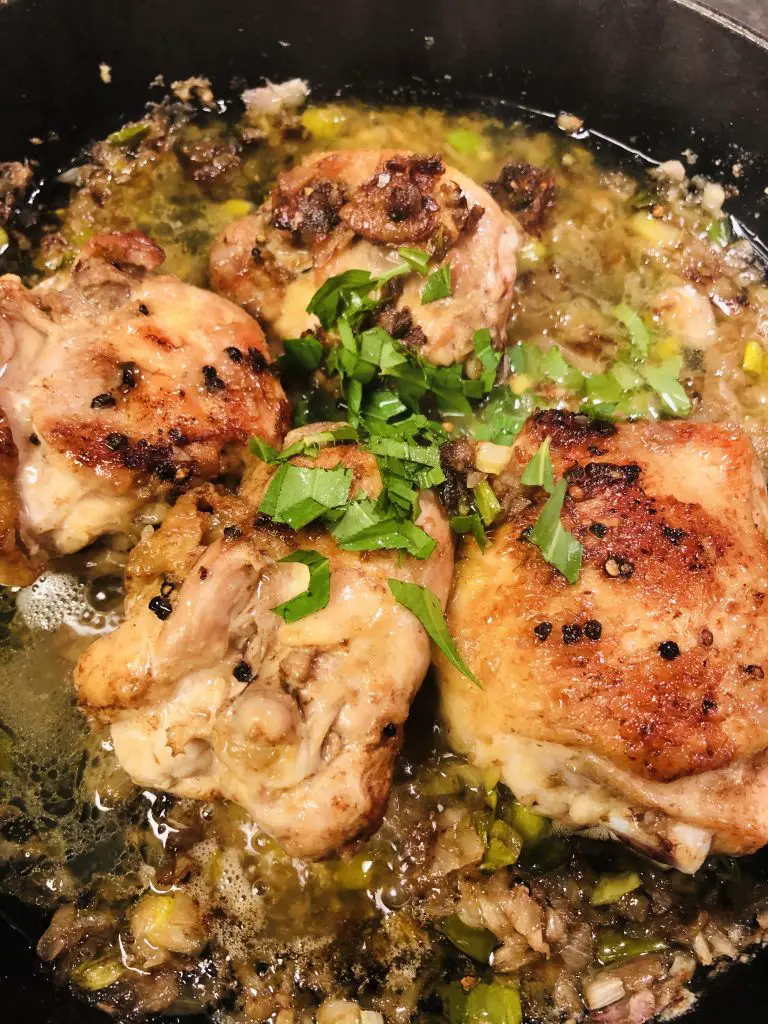 Chicken thighs browned in butter and topped with green onions