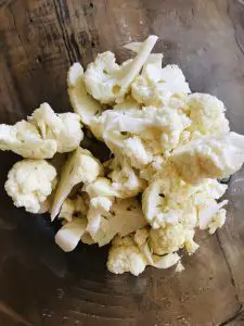 Cauliflower cut into small pieces in a glass bowl