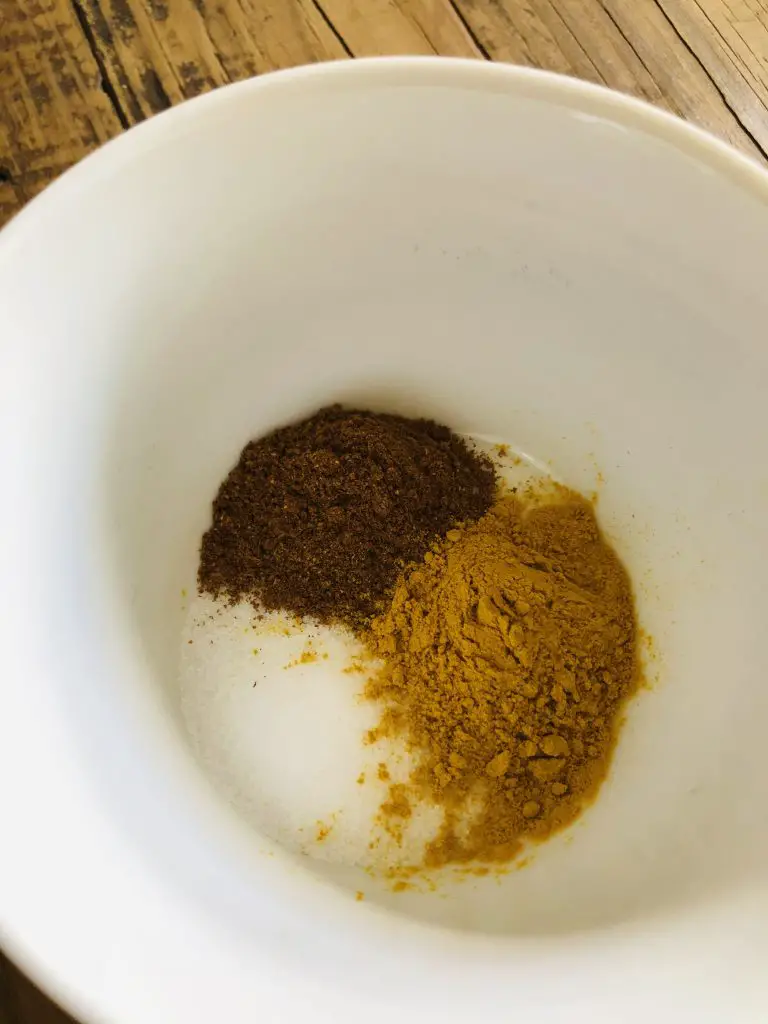 Salt, garam masala, turmeric in a white bowl