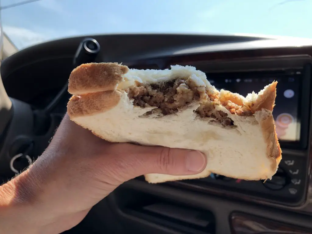 Hand holding a Smoked Boudin Sandwich