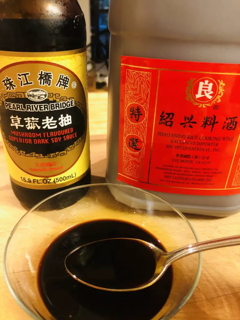 Dark Soy Sauce, Shaoxing Rice Wine and a glass bowl filled with a mixture of these 2 ingredients with a spoon 