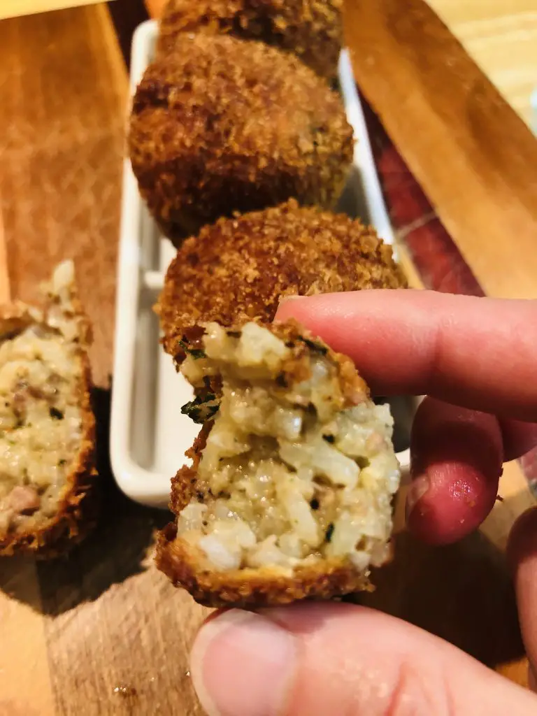 Fried Boudin Balls and a hand holding a boudin ball which was cut in half