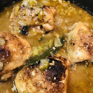 Cajun Smothered Chicken cooking in a cast iron pan