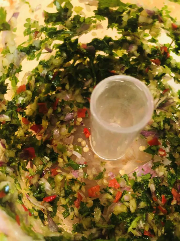 Minced Thai chilis, shallot, Thai basil, and cilantro in a food processor 