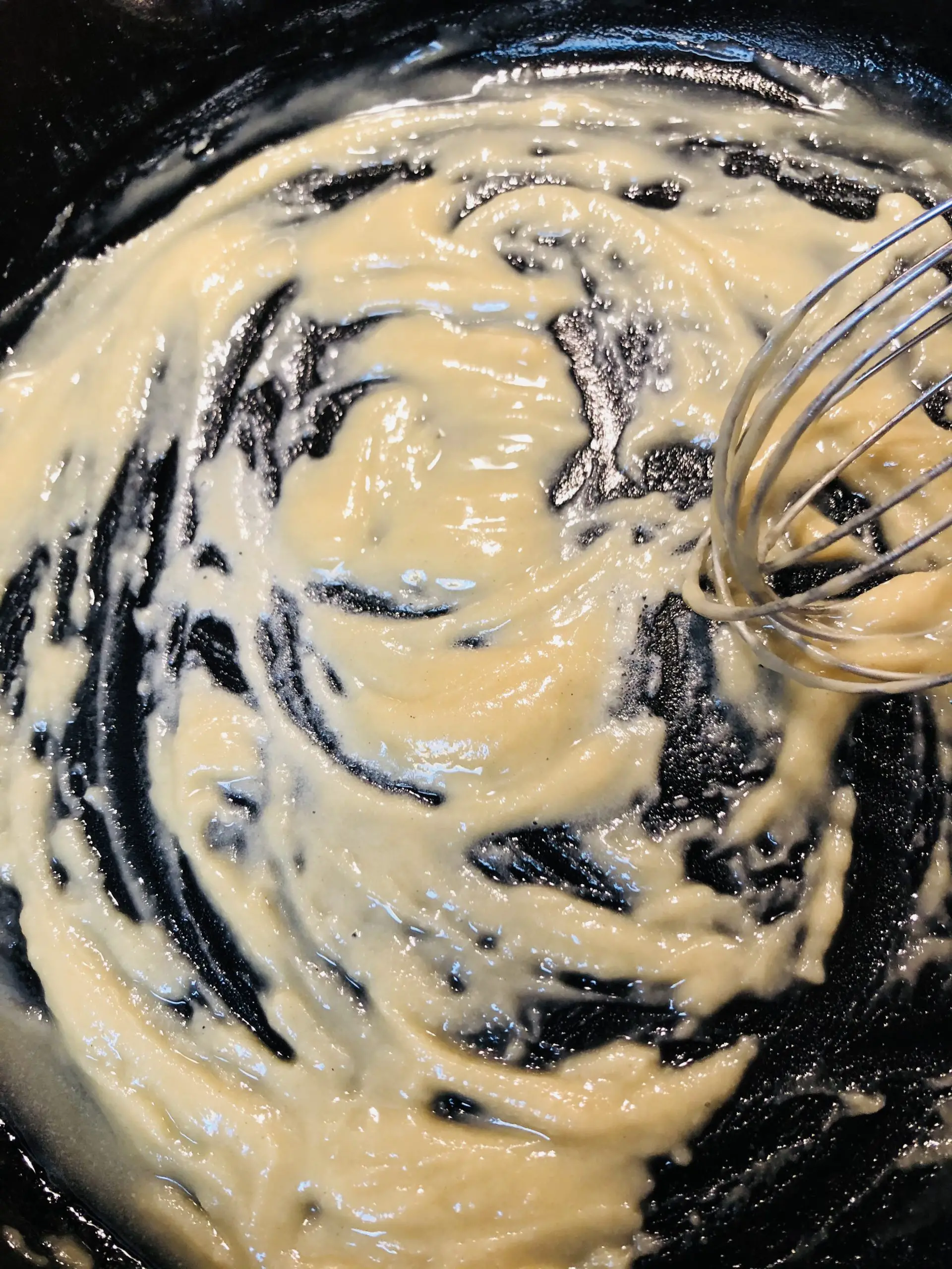 Roux in a cast iron pan with a whisk