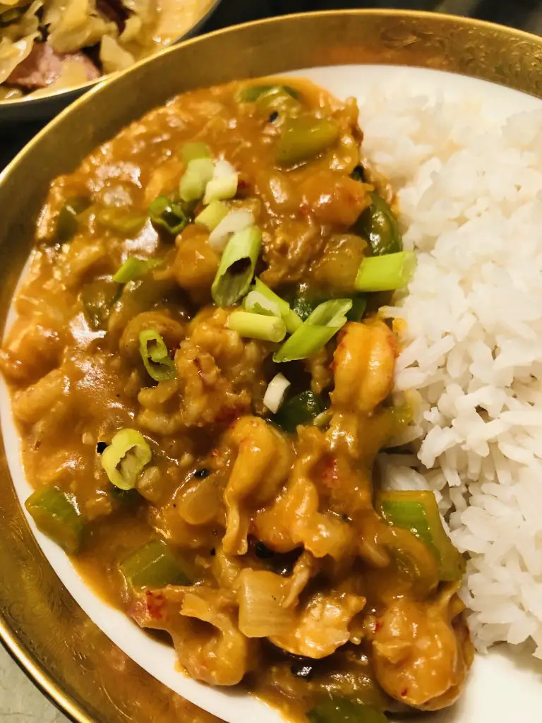 Crawfish Étouffée with white rice in a gold rimmed bowl 