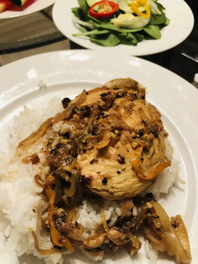 Chicken yassa and rice on a white plate