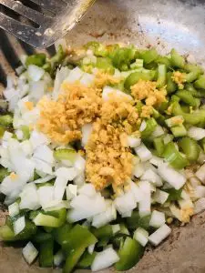 onion, green bell pepper, celery, and garlic in a skillet