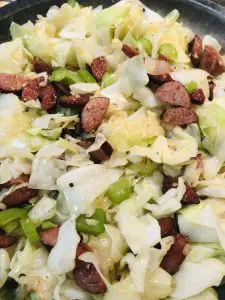 cabbage, andouille sausage, green bell pepper, celery and onion in a skillet