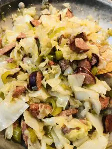 cabbage, andouille sausage, green bell pepper, celery and onion in a skillet