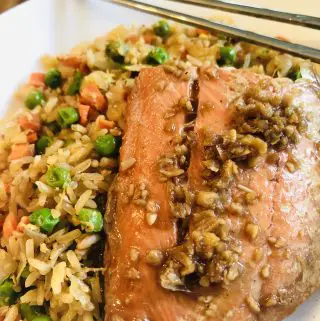 Asian Poached Salmon with fried rice in a white bowl and chopsticks on the side