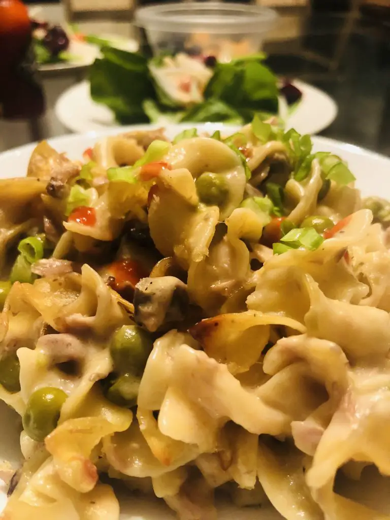 Tuna noodle casserole with a salad in the background