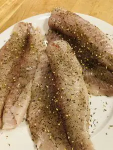 Uncooked Tilapia With Za'atar on a white plate