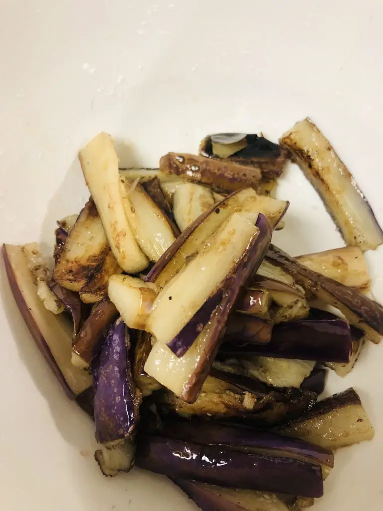 pieces of eggplant which have been stir fried in a white bowl