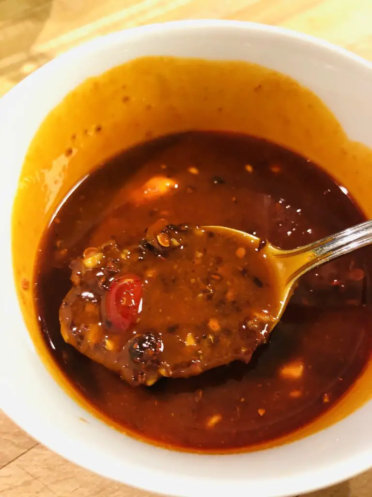 dan dan chili sauce in a white bowl with a spoon