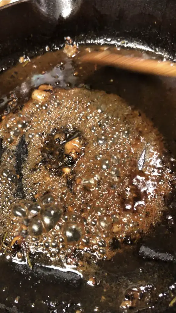 bubbling caramelized sauce in a cast iron pan