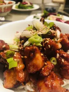 Spicy Chicken Bulgogi in a bowl garnished with green onions and sesame seeds