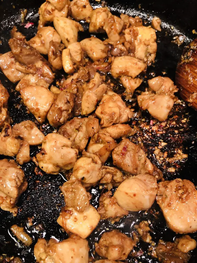 pieces of chicken browned and cooked in a cast iron skillet