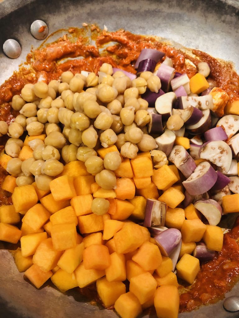 Panang curry paste topped with chickpeas, cubed butternut squash, diced eggplant