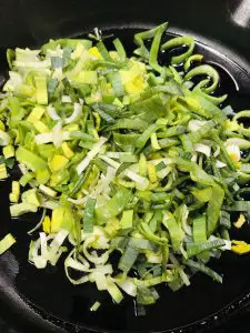 chopped leeks in a cast iron skillet