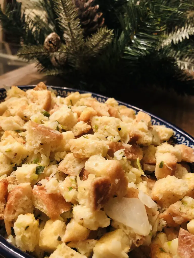 Sage and Onion Stuffing in a bowl with greenery in the background
