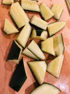 cut up pieces of cucumber on a wooden board