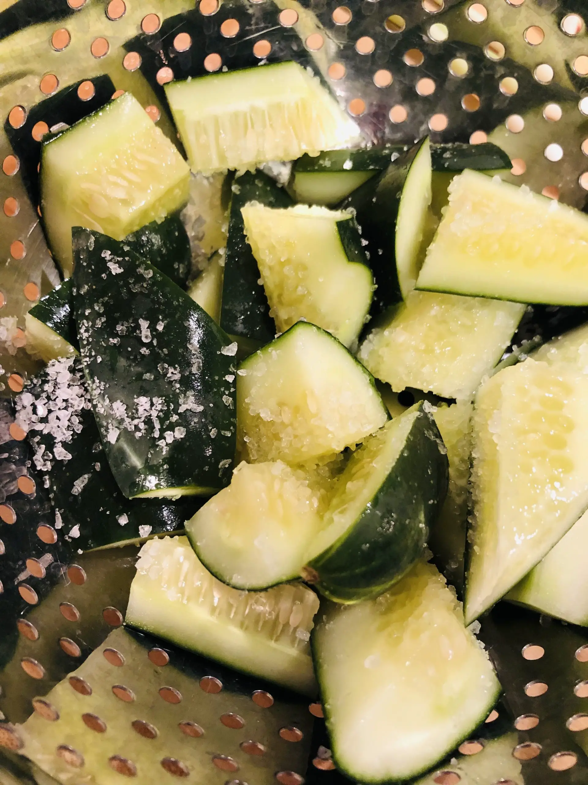 cut up pieces of cucumber sprinkled with salt in a colander