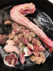 Goose neck and chopped gizzards browning in butter in a skillet