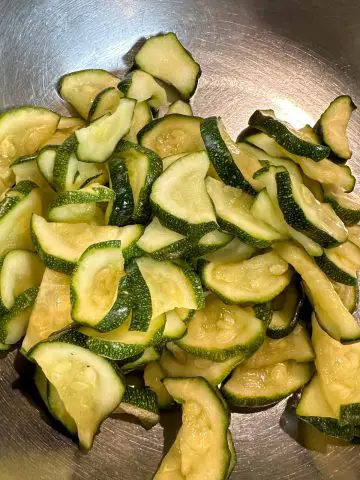 Slices of zucchini that have been squeezed so that the water has been removed from the zucchini.
