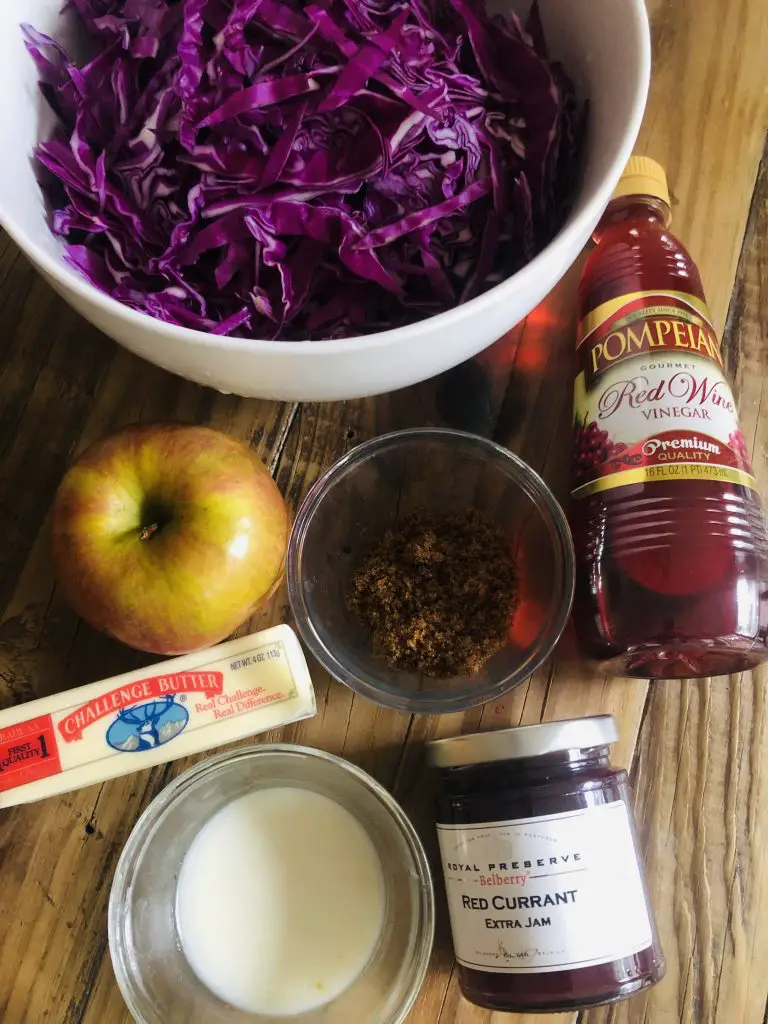 sliced red cabbage in a white bowl, red wine vinegar, brown sugar, an apple, stick of butter, goose fat, and red currant jam