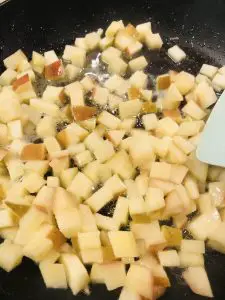 diced apple sautéing in a pan with butter