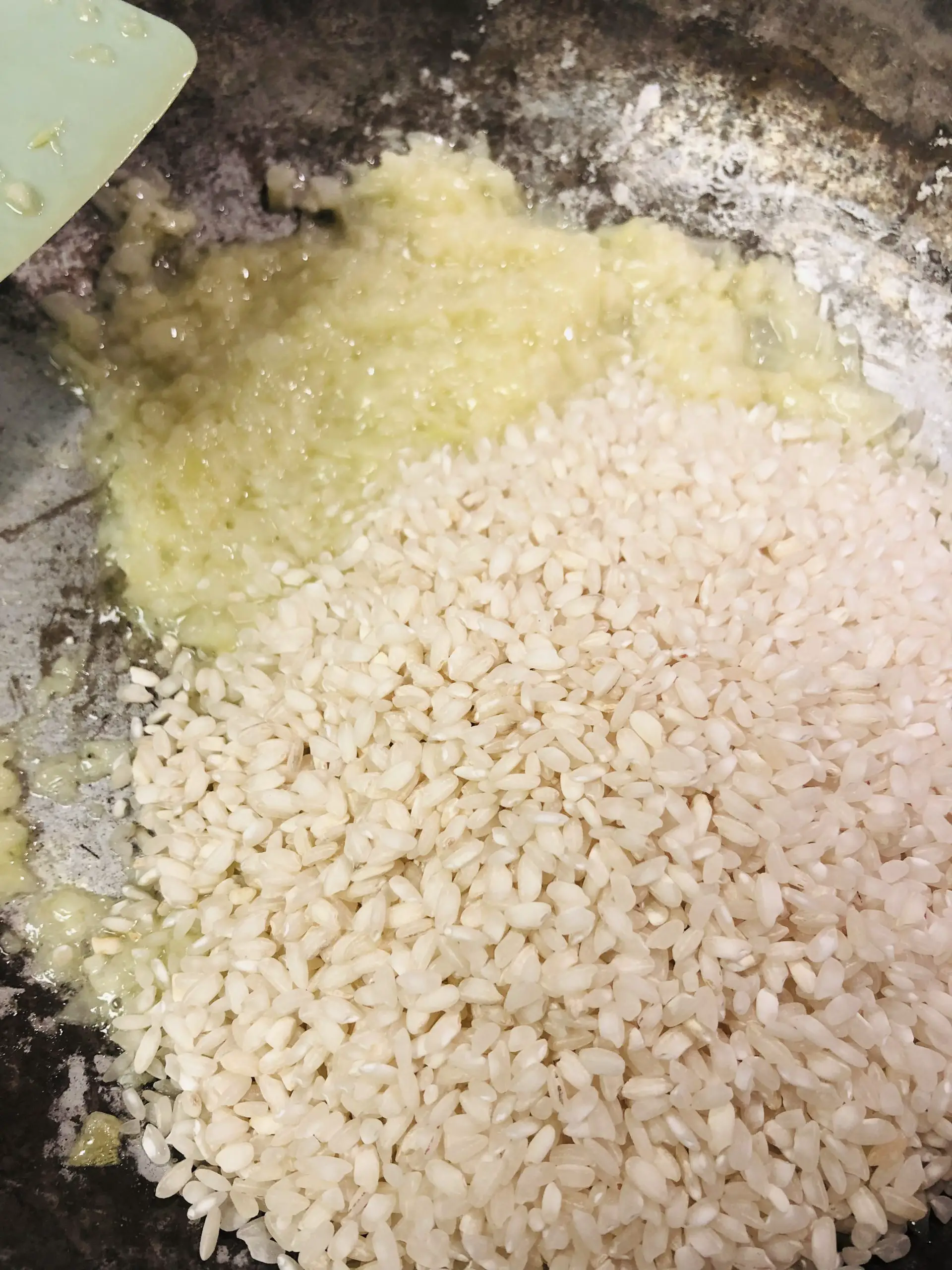 arborio rice with garlic and onion in a pan
