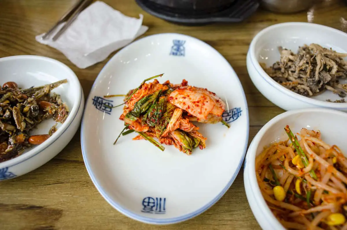 Several banchan dishes including kimchi and bean sprouts.