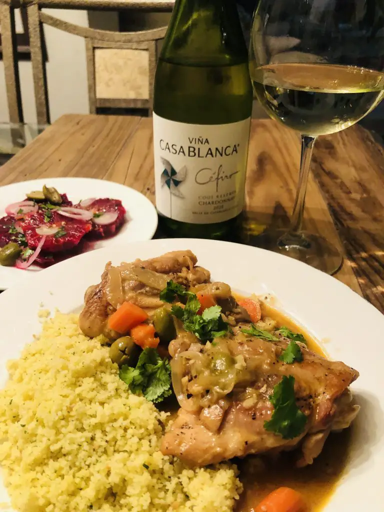 Moroccan orange salad, moroccan chicken tagine, couscous and Vina Casablanca wine in a bottle and a glass