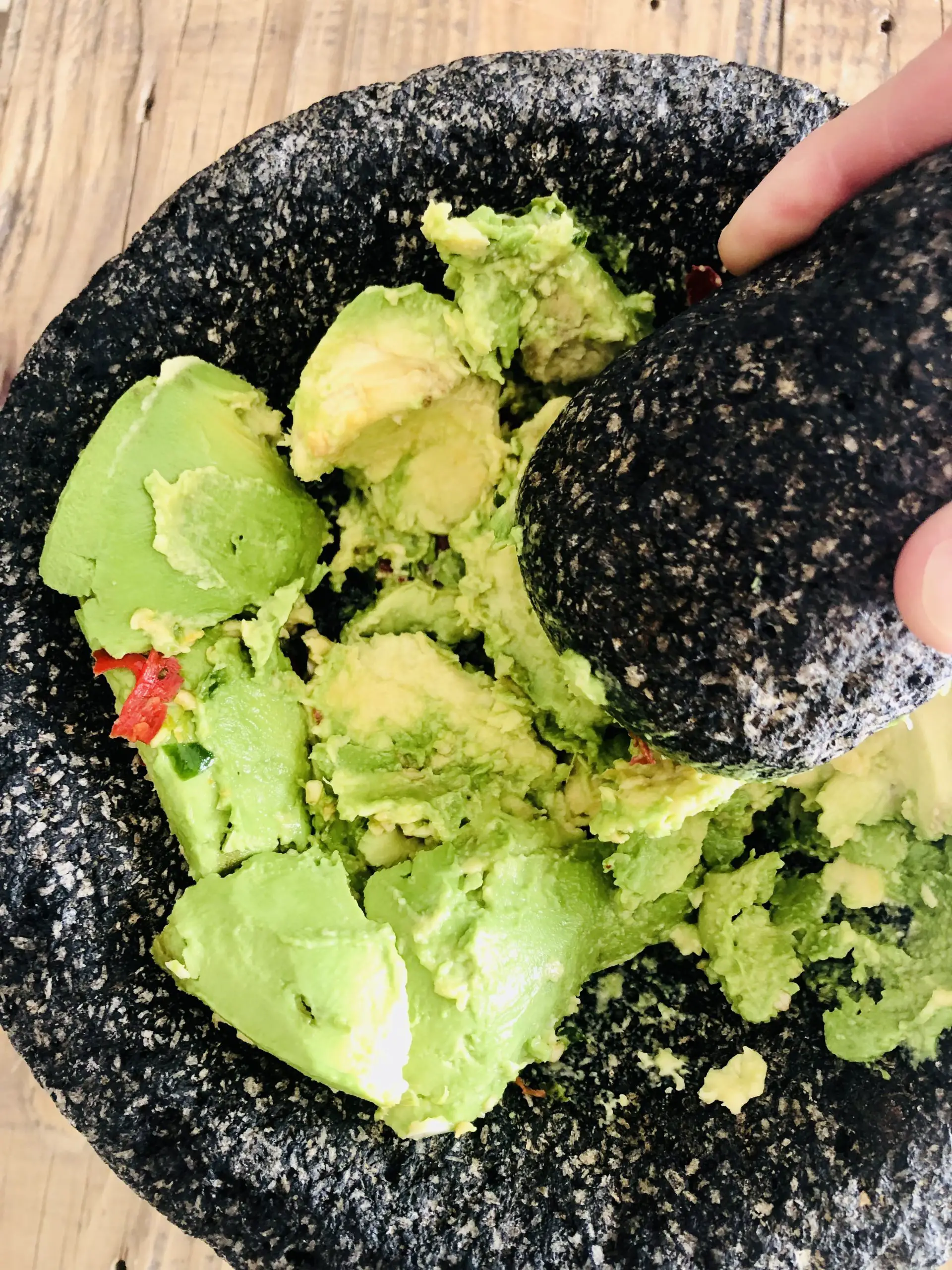 Mashed avocado in a molcajete with a pestle